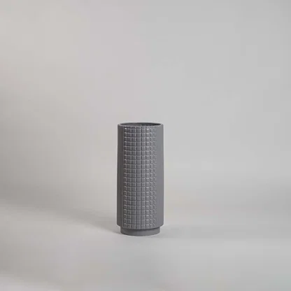 Grey grid textured ceramic cylinder vase with a stepped base profile on white background for contemporary interior styling.