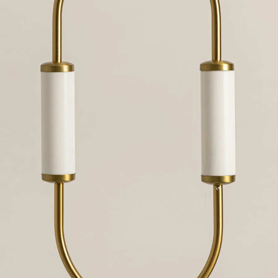 Gold metal wall light closeup highlighting curved frame detailing and premium contemporary lighting craftsmanship quality.