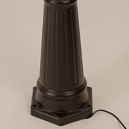 Detailed view of black metal outdoor lamp post highlighting glass lantern shape and textured pole for outdoor lighting.