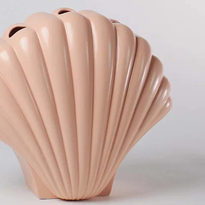 Close view of a pastel peach shell shaped vase showing the detailed ridged pattern and smooth high gloss ceramic finish.