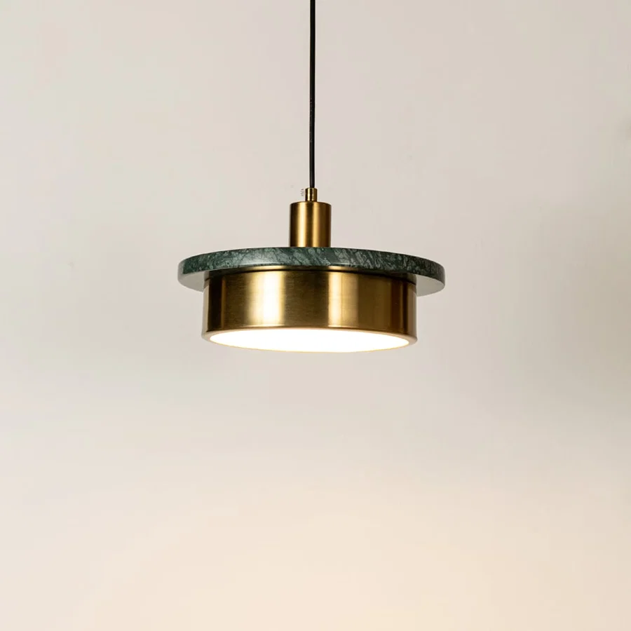 Gold metal pendant light illuminated with sleek cylindrical design highlighting contemporary hanging light craftsmanship.
