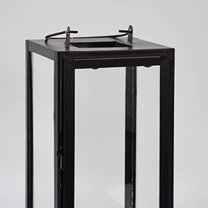 Closeup of minimal black metal lantern frame with clear glass panels for elegant decor styling use.