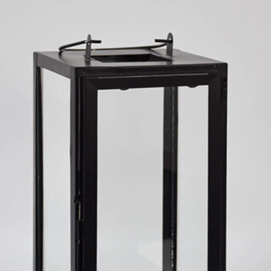 Closeup of minimal black metal lantern frame with clear glass panels for elegant decor styling use.