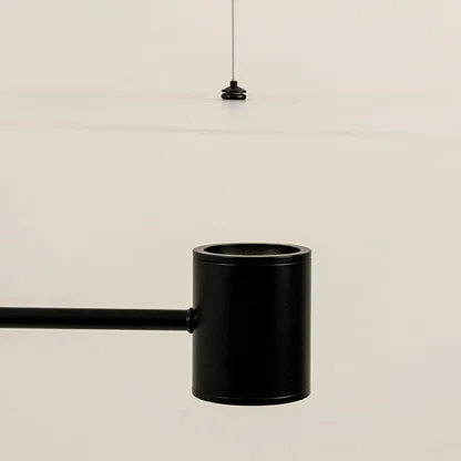 Black metal pendant light closeup highlighting cylindrical shade detailing and premium contemporary craftsmanship.
