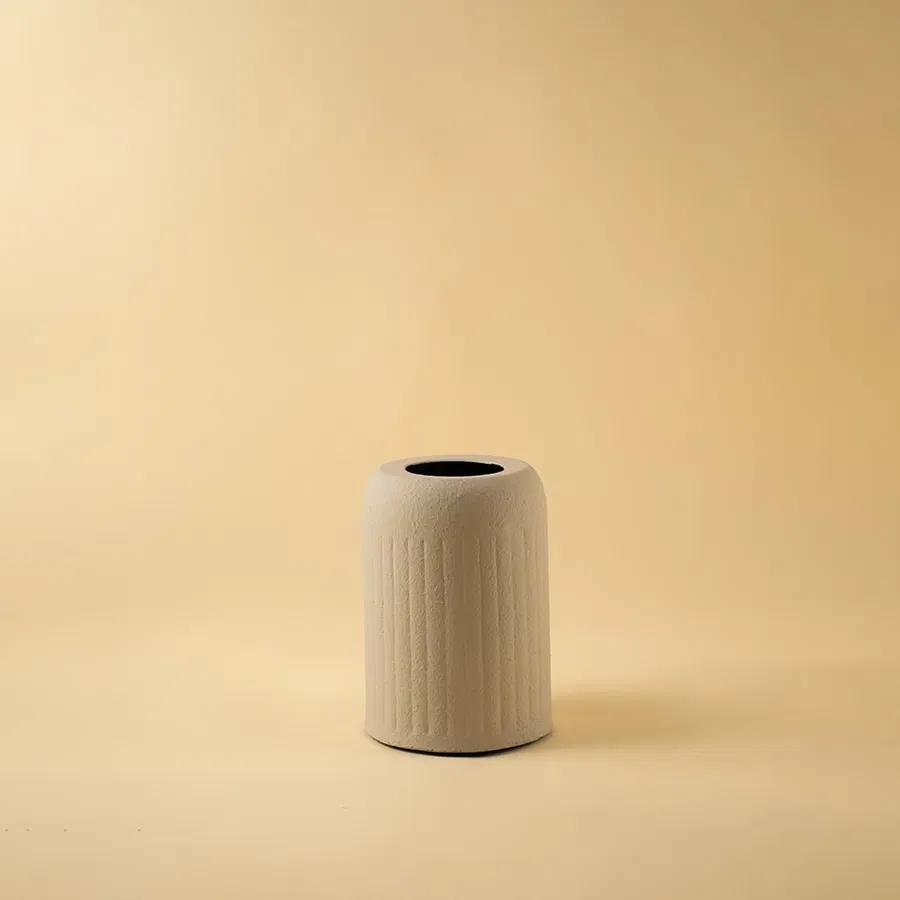 Beige ribbed ceramic vase displayed on a clean white background highlighting its texture and modern minimal design.