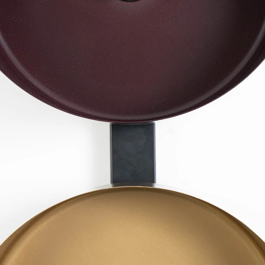 Top-down view of bronze and gold wall shades aligned on black frame showing texture and alignment detail.