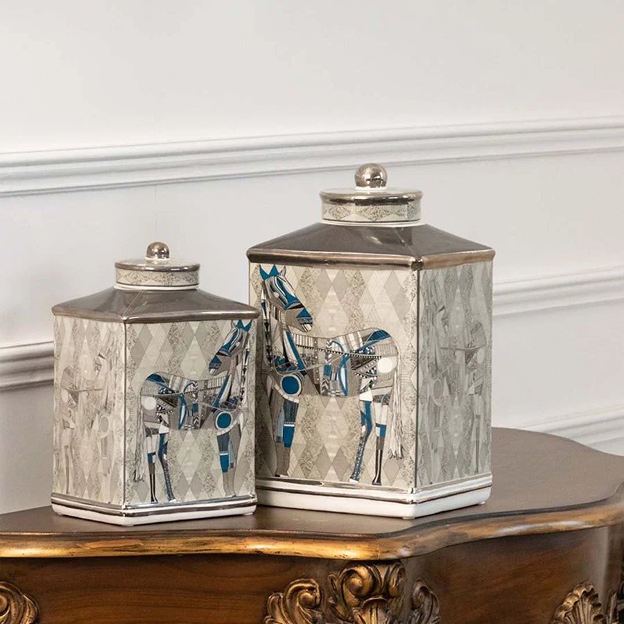 White jars with black abstract art placed on a wooden console table creating a modern artistic décor accent that enhances the interior space beautifully.