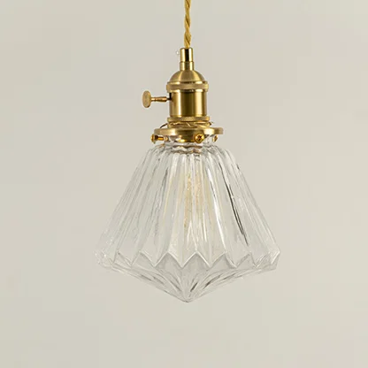 Clear faceted glass and brass metal pendant light designed for elegant dining room and home decor spaces.