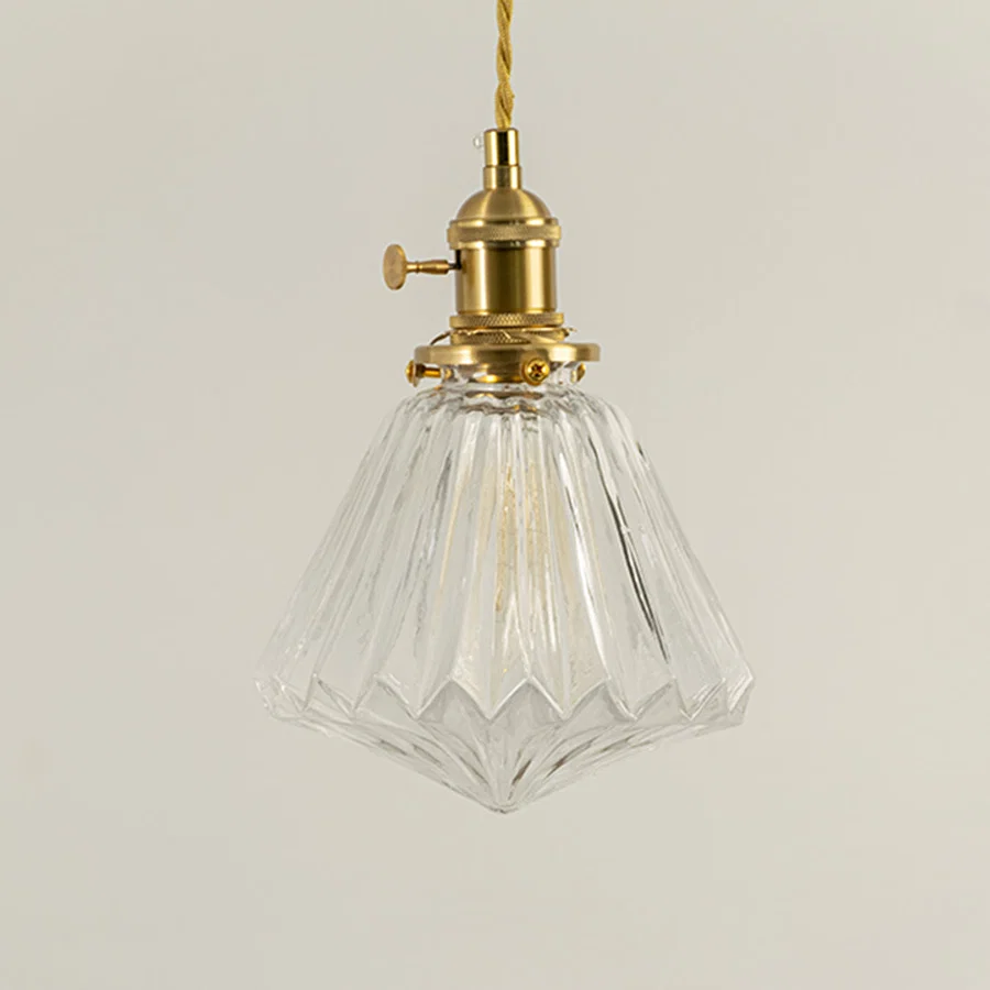 Clear faceted glass and brass metal pendant light designed for elegant dining room and home decor spaces.
