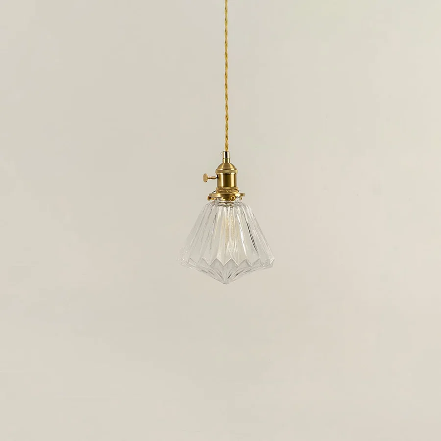 Clear textured glass and brass metal pendant light with vintage styling for refined interior spaces.