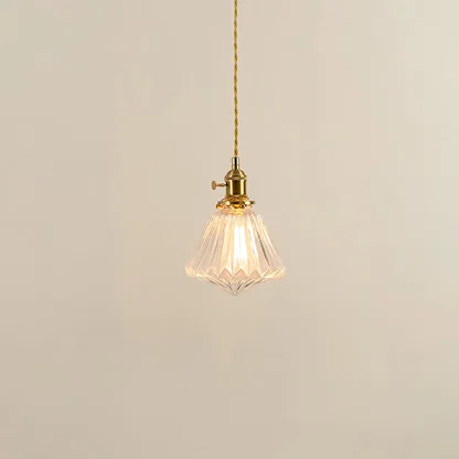 Clear textured glass and brass metal pendant light with warm illumination for modern decor spaces.