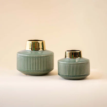 Set of sage green ceramic decorative vases with gold rims for coordinated shelf styling and modern home decor.