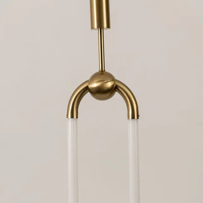 Closeup of gold metal pendant light with curved frame and glass shades on white background perfect for modern lighting decor.
