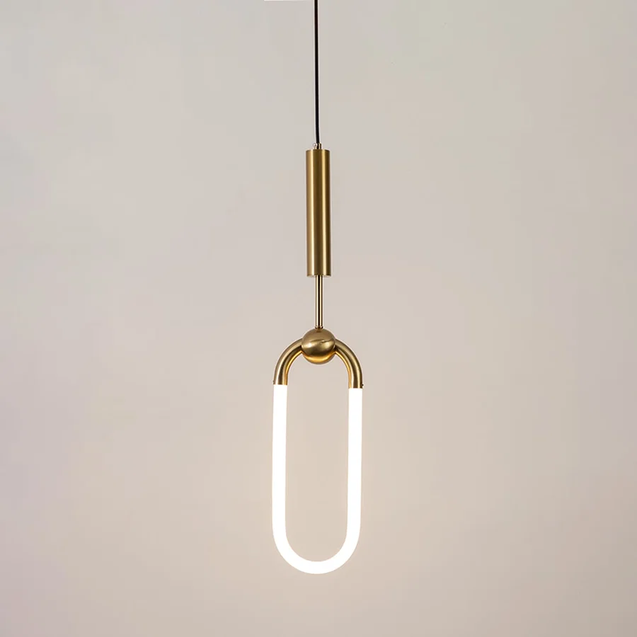 Gold metal pendant light with frosted acrylic loop illuminated to showcase minimalist contemporary ceiling lighting.