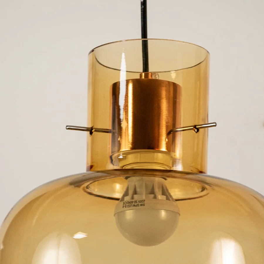 Amber glass pendant light closeup showcasing textured glass shade and premium decorative lighting craftsmanship details.