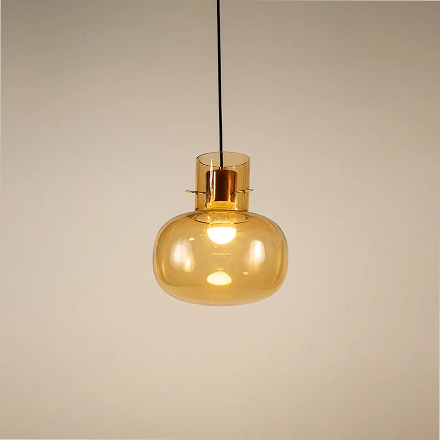 Amber glass pendant light displaying elegant hanging design with warm decorative appeal and contemporary styling.