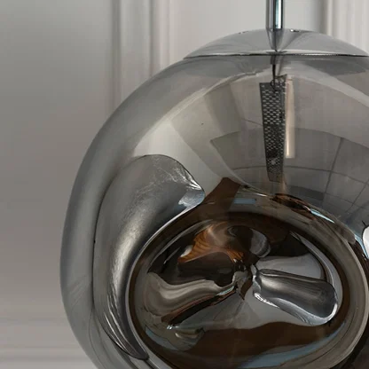 Detailed view of smoky glass pendant light with reflective finish highlighting refined craftsmanship.