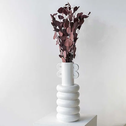 Deep red dried eucalyptus stems styled in a warm modern room adding rich earthy texture to contemporary home decor.