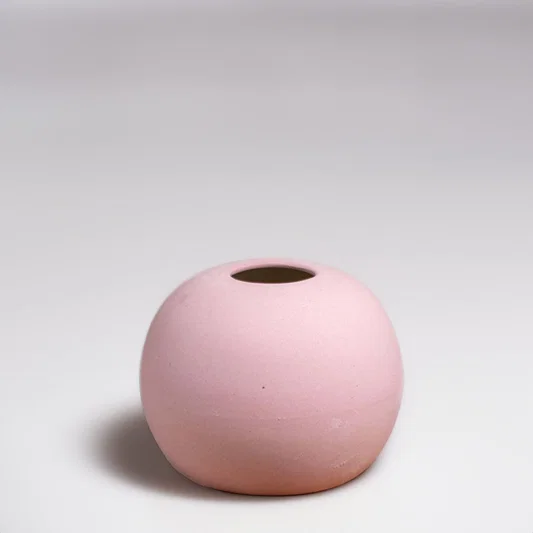 Pink ceramic decorative vase with rounded minimalist silhouette for elegant tabletop styling and modern home decor.