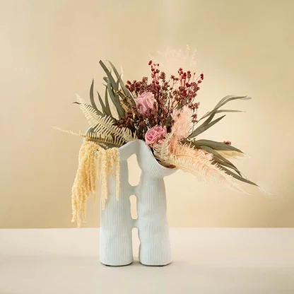 Modern white ceramic vase featuring fluid sculptural shape and minimalist ribbed texture for elegant interior styling.