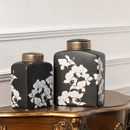 Set of black ceramic decorative jars with white floral artwork for luxury shelf styling and modern home decor.