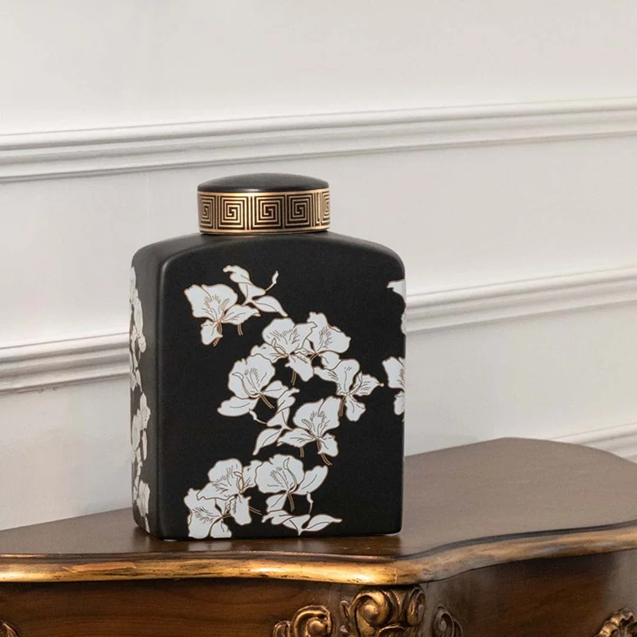 Black ceramic jar decorated with white cherry blossom artwork designed for oriental décor adding artistic contrast handcrafted beauty and elegant detailing to sophisticated interior spaces.