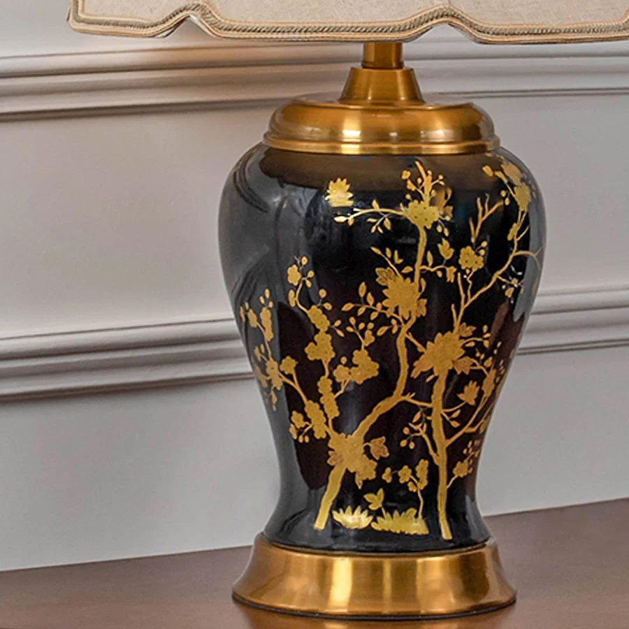 Black gold floral lamp on wooden console table with light on and white panelled wall background for classic luxury d‚àö¬¢¬¨√†¬¨√∂‚àö√á¬¨¬©cor.