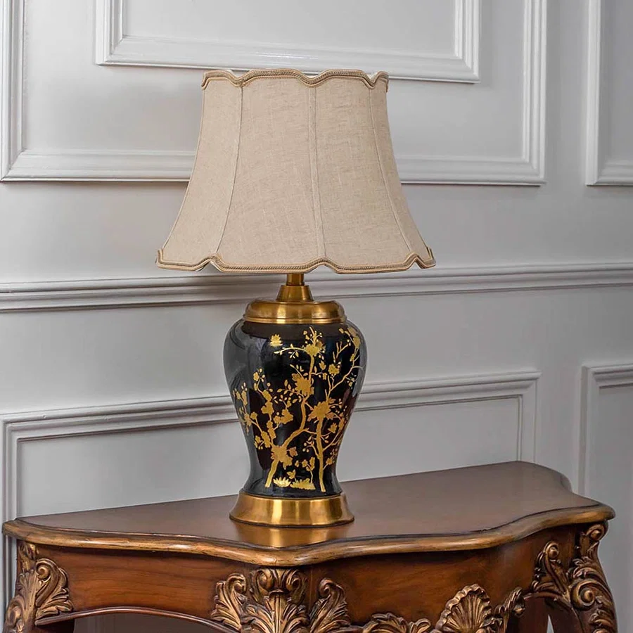 Gold patterned lamp on carved console table with light on and white panelled wall background for classic d‚àö¬¢¬¨√†¬¨√∂‚àö√á¬¨¬©cor.