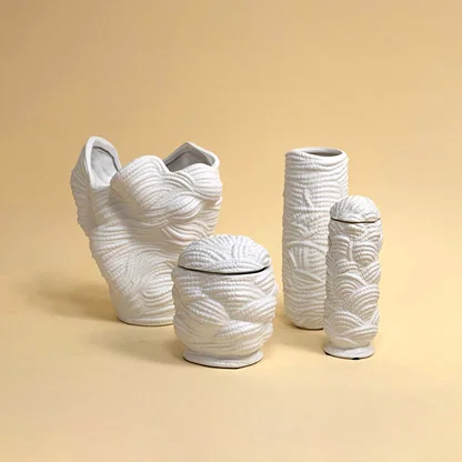 Set of white ceramic decorative vases with textured patterns for elegant shelf styling and modern home decor.