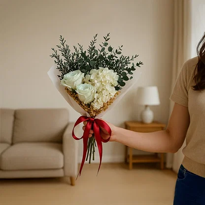 Elegant dried flower bouquet with white infinity rose hydrangea and eucalyptus wrapped with satin ribbon for home decor.