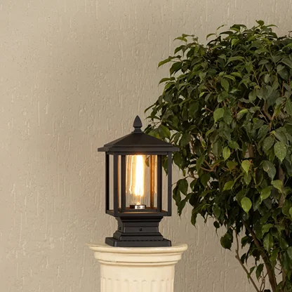 Black metal outdoor post light with ribbed glass Light On placed on a decorative column Lifestyle image patio decor.