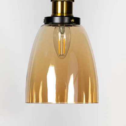 Amber glass pendant light with brass metal fixture showcasing smooth glossy finish and warm contemporary lighting style.