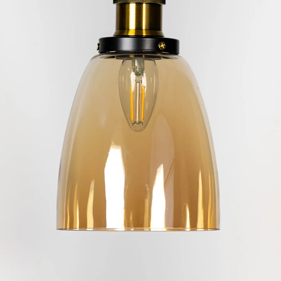 Amber glass pendant light with brass metal fixture showcasing smooth glossy finish and warm contemporary lighting style.