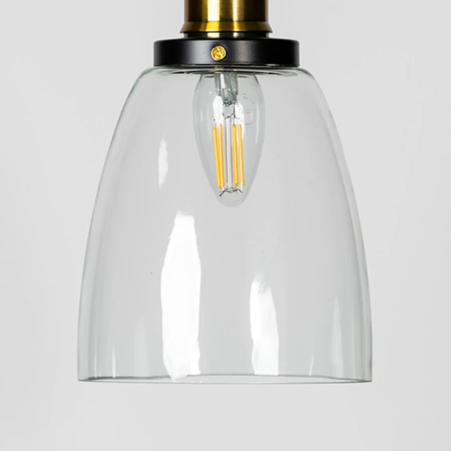 Clear glass pendant light with brass metal fixture showcasing smooth transparent finish and modern lighting style.