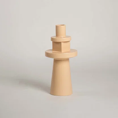 Peach terracotta ceramic architectural totem vase with geometric stacked tiers on white background for contemporary art.