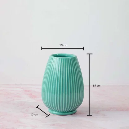 Textured ceramic vase in teal finish showing approx twenty two cm height and thirteen cm diameter designed for table and shelf decor.