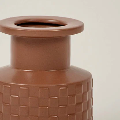 Closeup of terracotta ceramic vase showing basket weave texture and matte finish ideal for minimal home interiors.