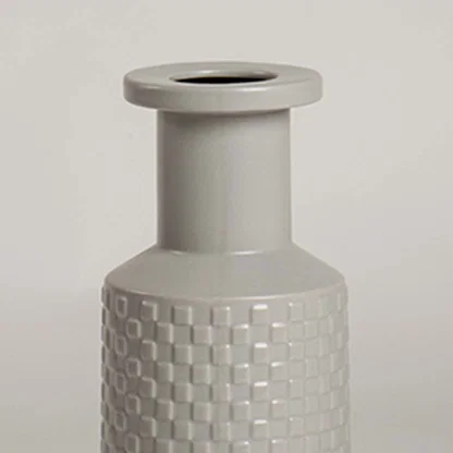 Closeup of light grey ceramic vase highlighting its embossed textured design and smooth finish ideal for stylish modern home decor.