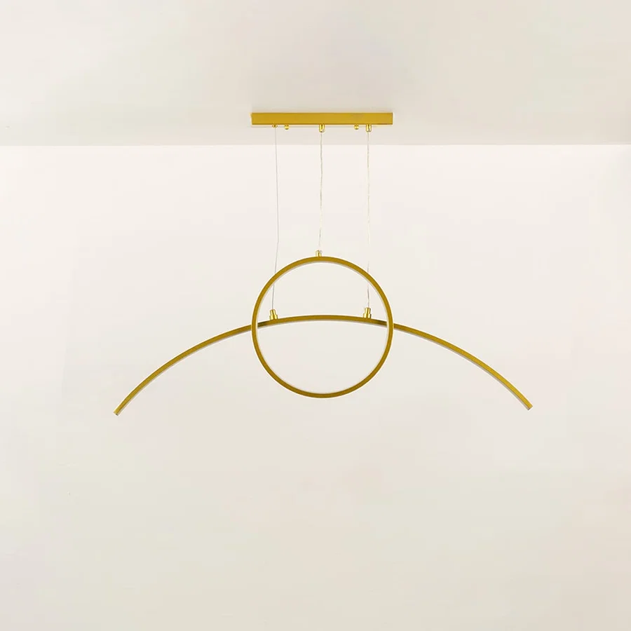 Minimal gold metal wall light with curved linear design shown unlit on black background for modern architectural lighting decor.