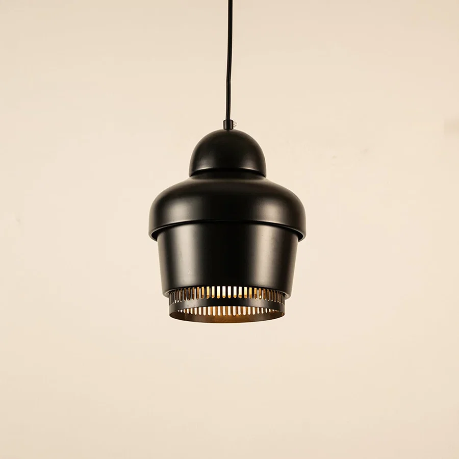 Black metal pendant light with industrial design illuminated to highlight modern ceiling lighting and warm glow.