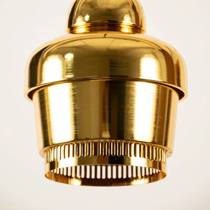 Gold metal pendant light closeup highlighting premium detailing and luxury craftsmanship with modern decorative appeal.