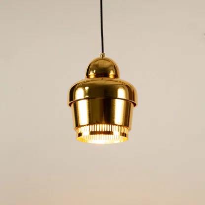 Gold metal pendant light illuminated to display luxury ceiling lighting with elegant modern decorative styling.