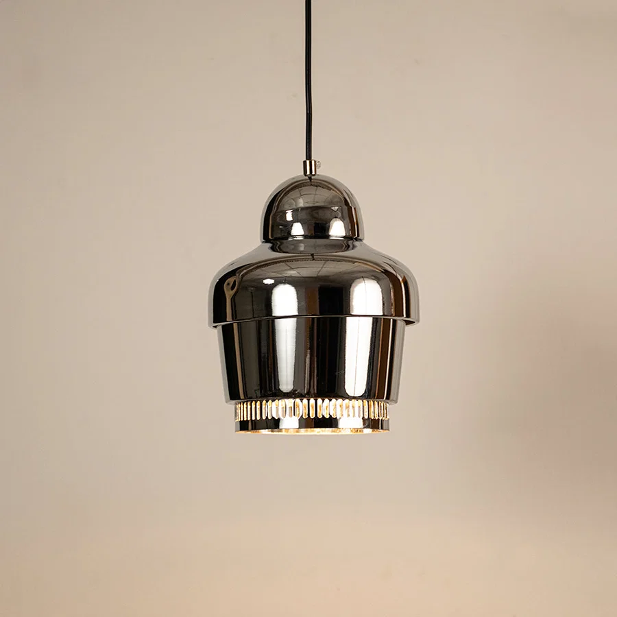 Silver metal pendant light illuminated to display sleek ceiling lighting design with contemporary decorative appeal.