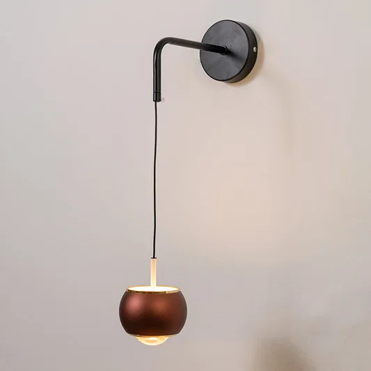 Modern black and brass pendant wall light with warm glow for elegant bedroom interior decor.