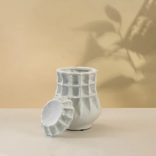 White ceramic decorative vase with geometric sculptural texture for minimalist shelf styling and modern home decor.