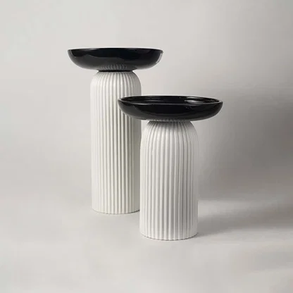 A stylish pedestal bowl in black and white shown in a grouped decor setup adding a bold contemporary touch to modern home styling.