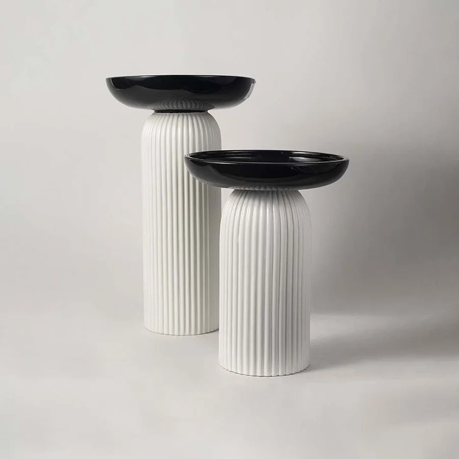 A stylish pedestal bowl in black and white shown in a grouped decor setup adding a bold contemporary touch to modern home styling.