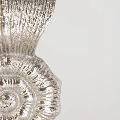 Closeup shell decor piece in silver finish with textured pattern for table decor or shelf styling contemporary home placement white background.