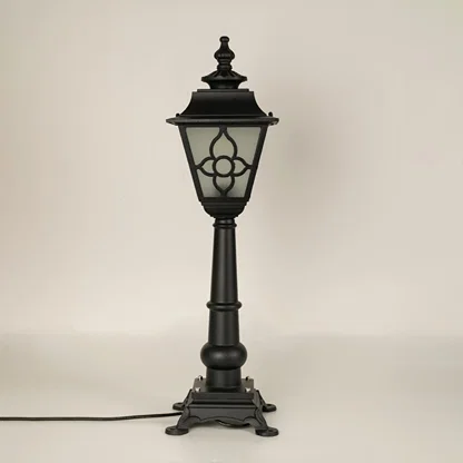 A vintage style outdoor pillar lamp shown on a white background with the light off highlighting its frosted glass panels curved lantern top and detailed sculpted base.
