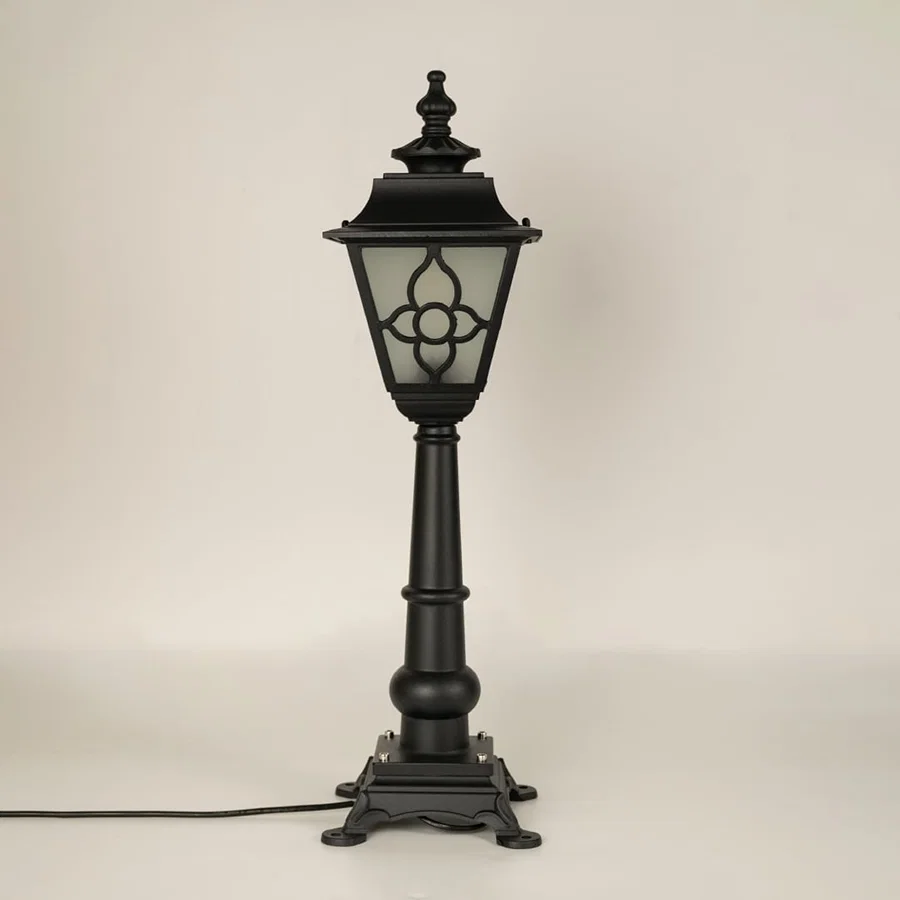A vintage style outdoor pillar lamp shown on a white background with the light off highlighting its frosted glass panels curved lantern top and detailed sculpted base.